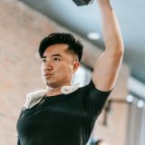 Homme réalisant un développé épaules overhead press